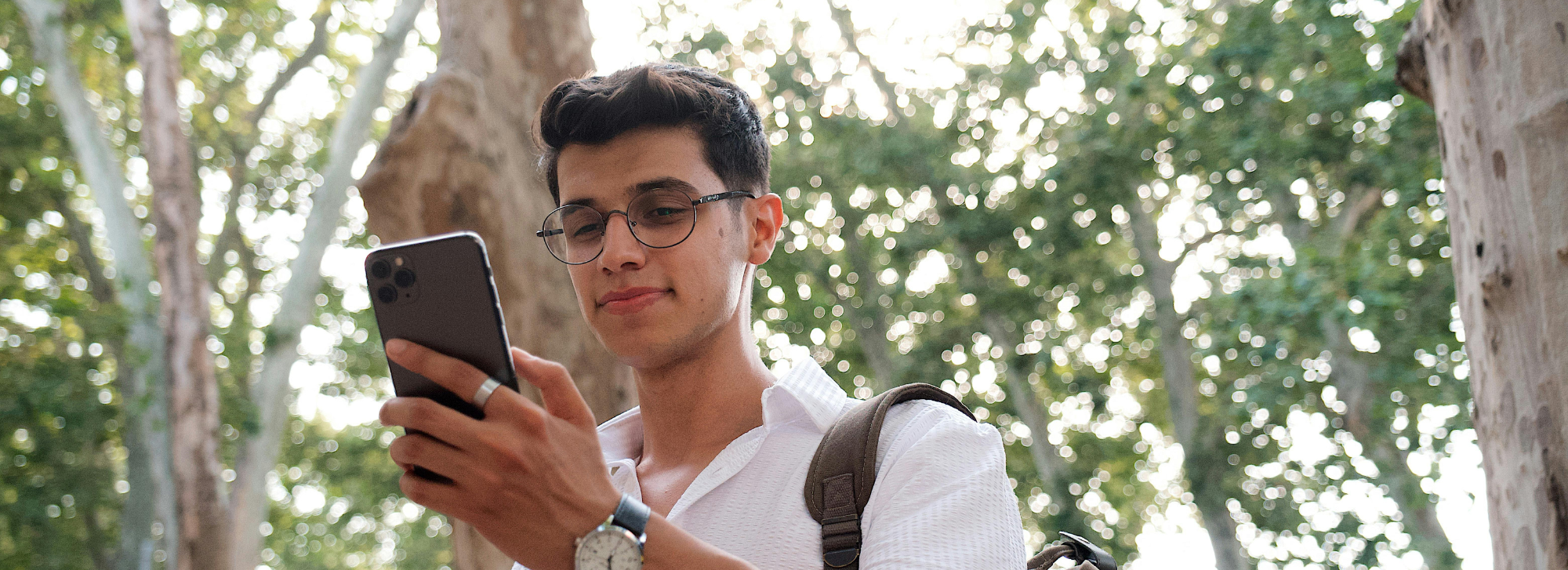 Person on their phone in the woods.