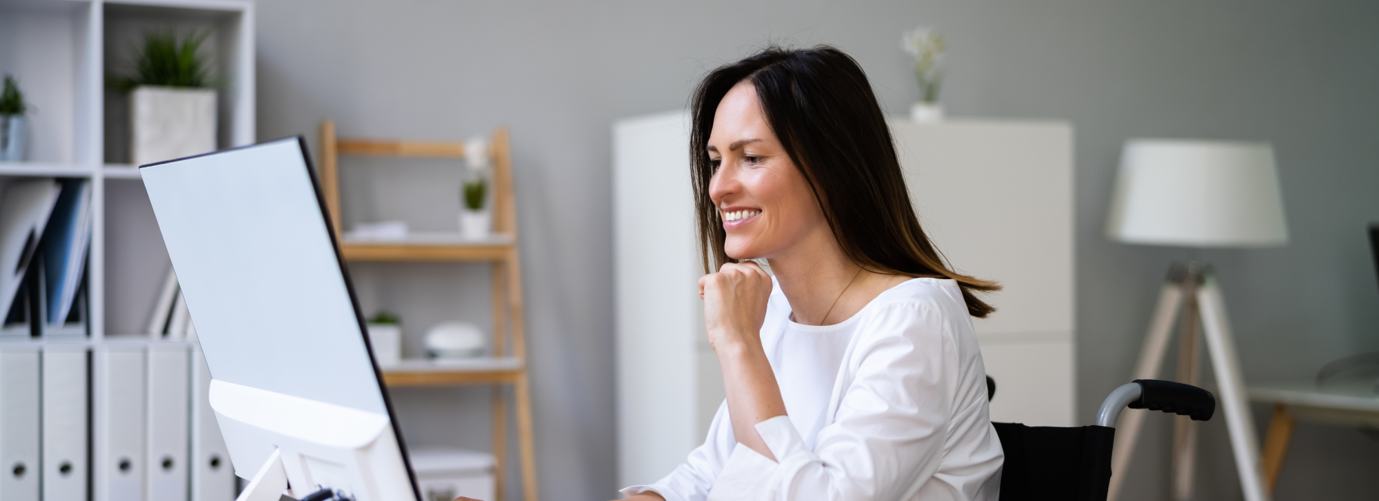 A woman looking at her computer in an office setting.