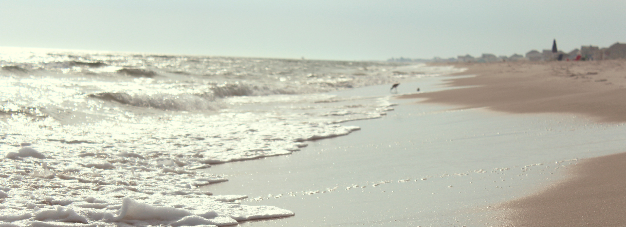 Waves rolling up the beach sand.