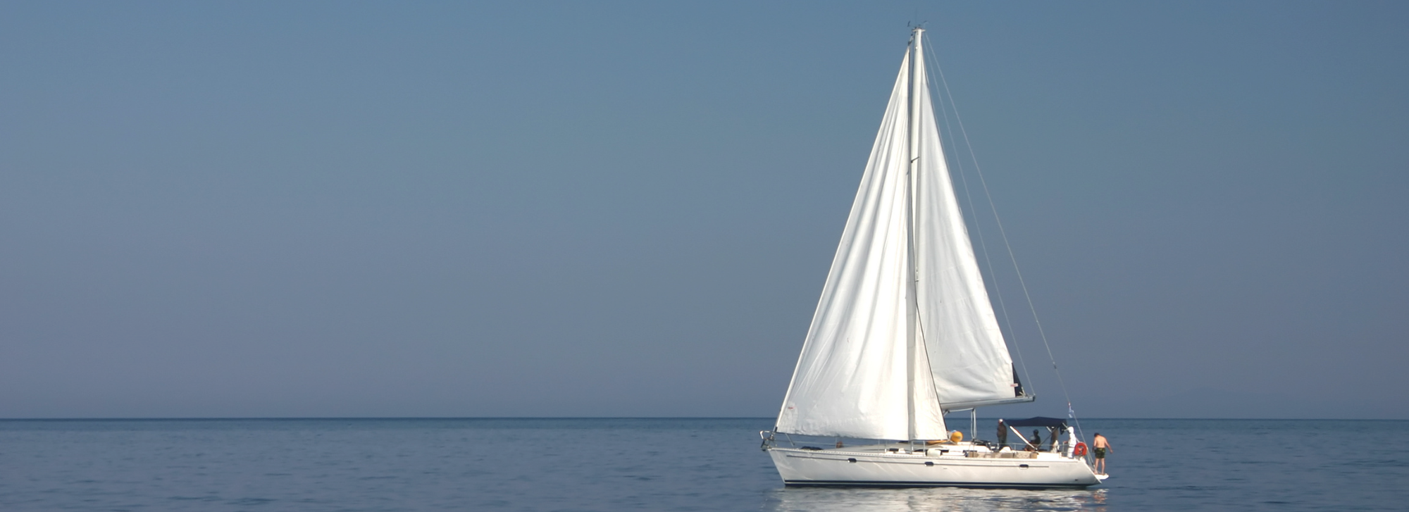 A white sailboat on a lake.